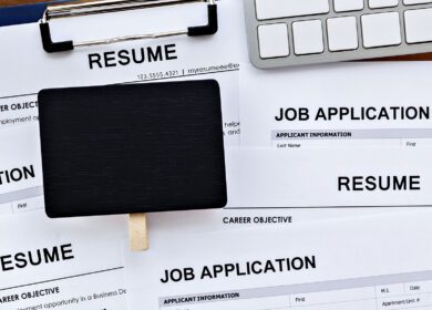 Job search with blank sign and lots of resume and job applications on computer work table